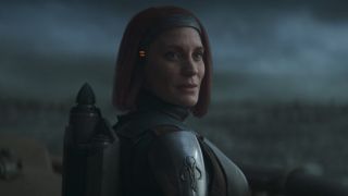 Katee Sackhoff's Bo-Katan smiling as Din Djarin walks away on The Mandalorian